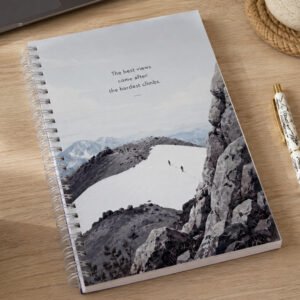 Lassen hikers notebook with mountain cover on a wooden desk beside a pen