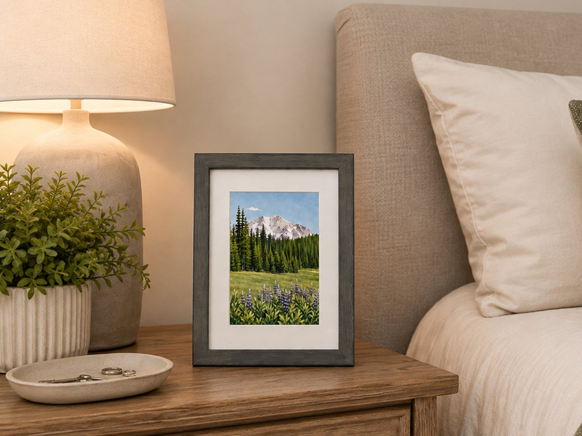 Mount Lassen 4x6 art print with purple lupine in a gray frame on a bedroom nightstand